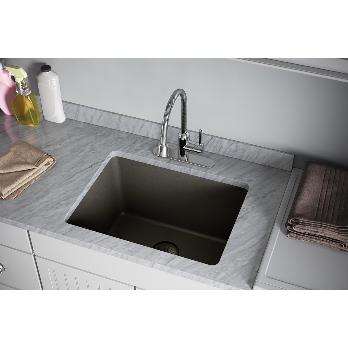 Dusk gray polymer basket strainer and rubber stopper installed in a black undermount kitchen sink drain.