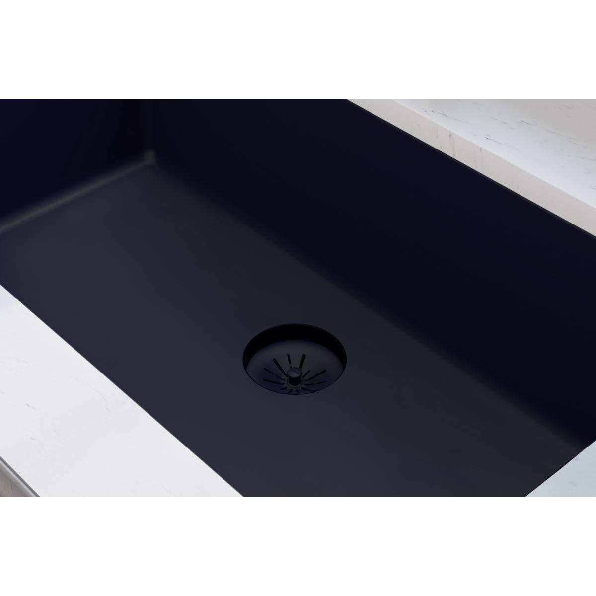 Black basket strainer with radiating slots installed in dark quartz sink basin.