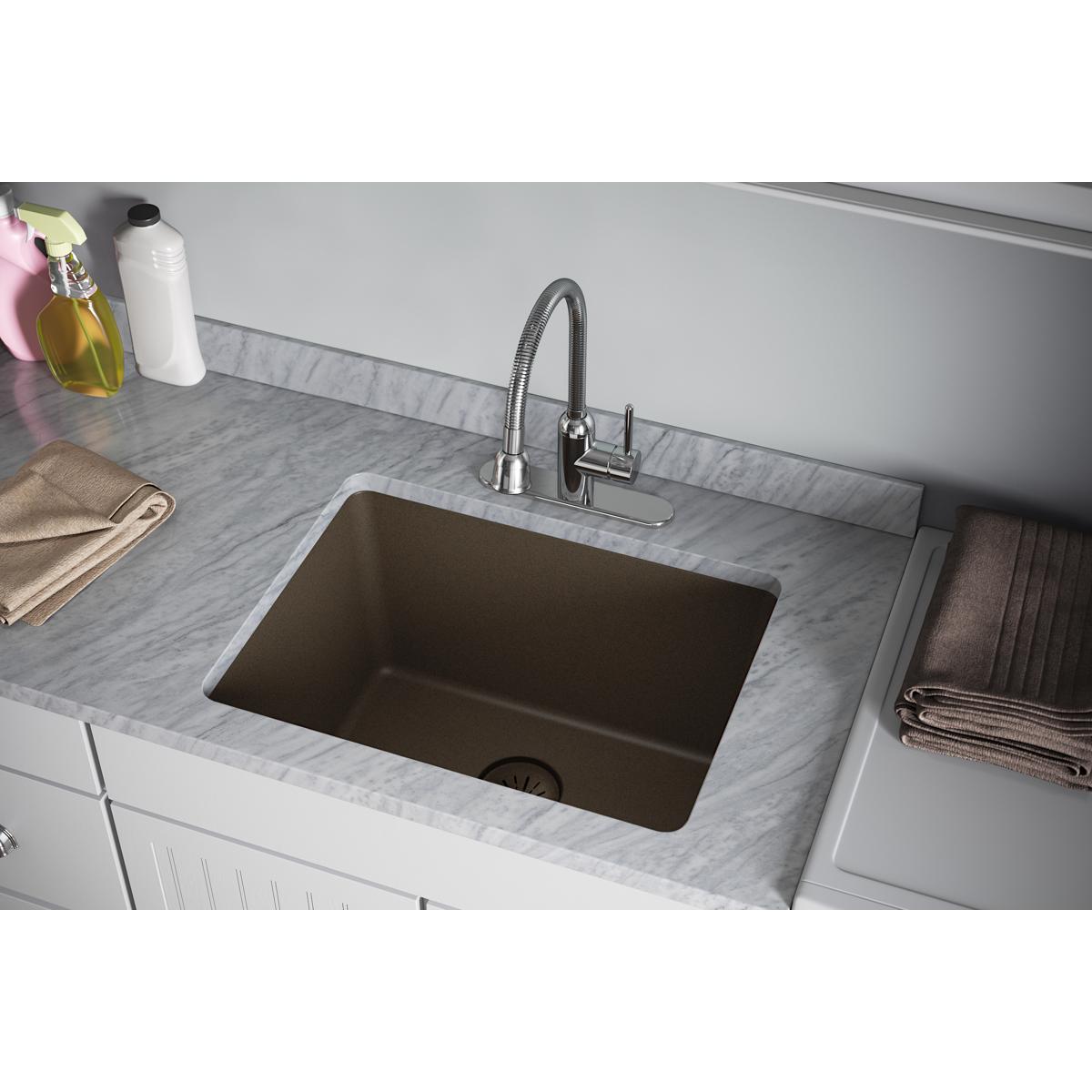 Mocha quartz kitchen sink with drain basket strainer and rubber stopper installed in countertop.