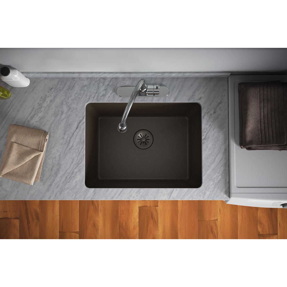 Mocha quartz sink with circular drain strainer and rubber stopper installed in countertop.