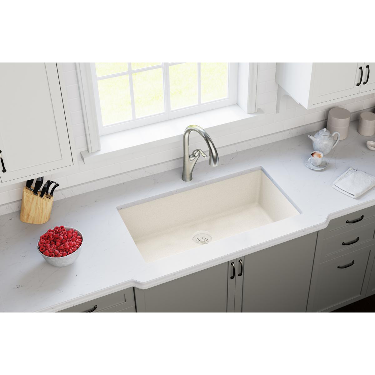 Parchment-colored quartz sink with stainless steel drain strainer visible in kitchen countertop.