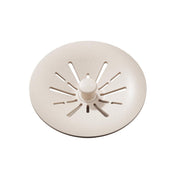 Beige polymer basket strainer with radial slots and center post for sink drain.