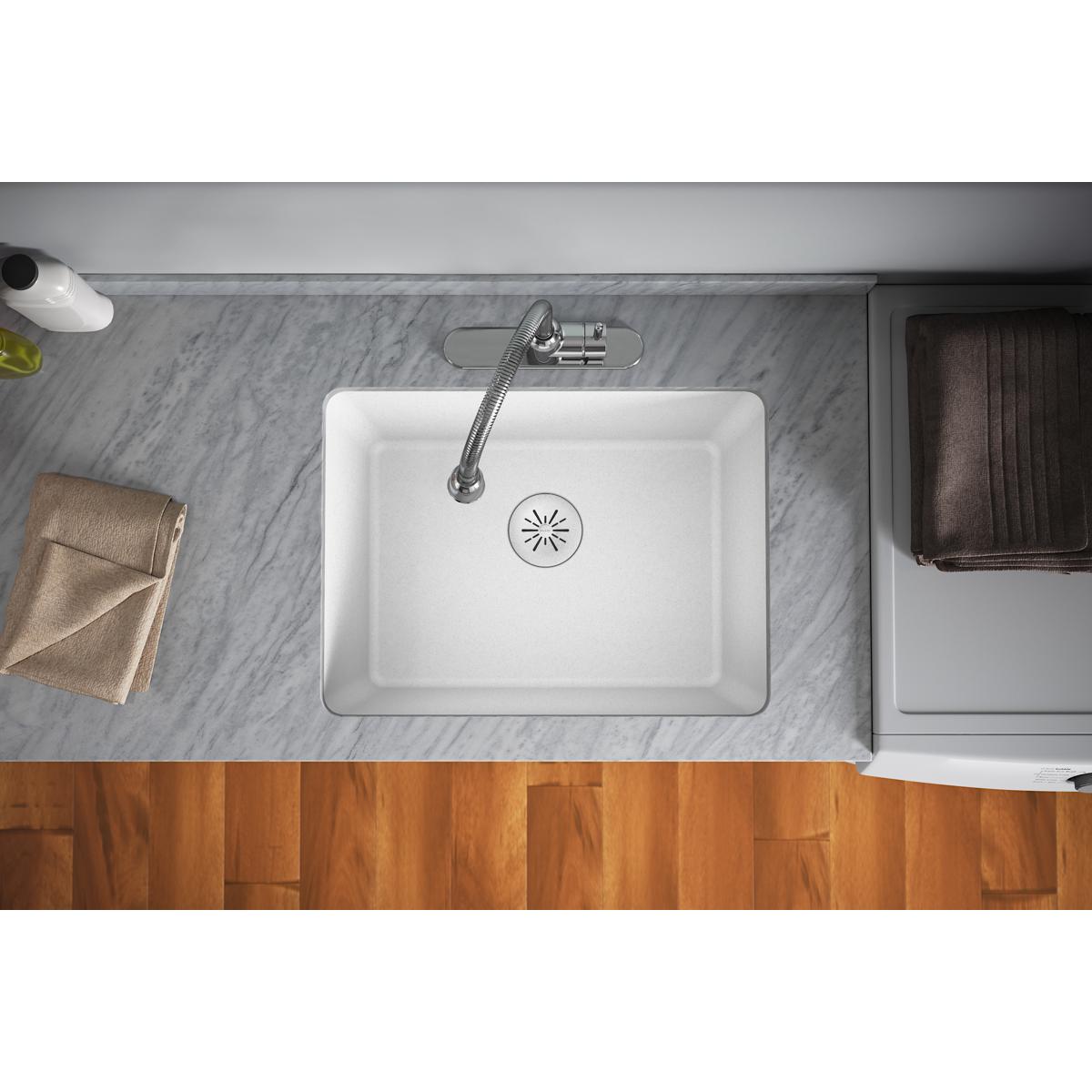 White quartz sink with chrome faucet and visible drain strainer basket in center.