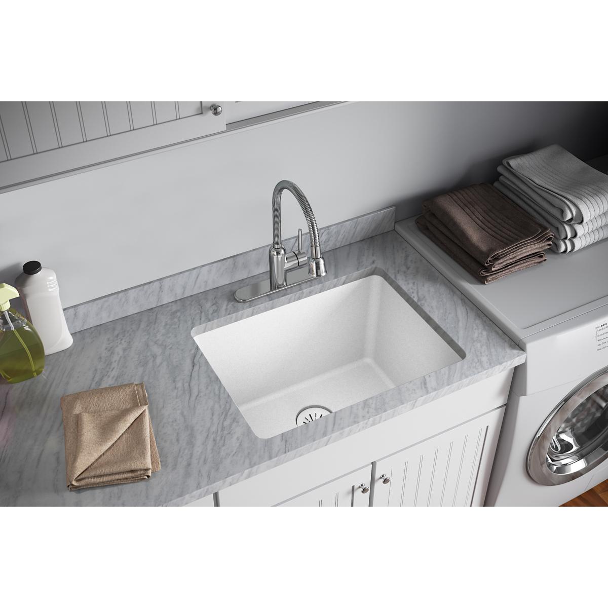 White polymer basket strainer and rubber stopper installed in white quartz sink drain.