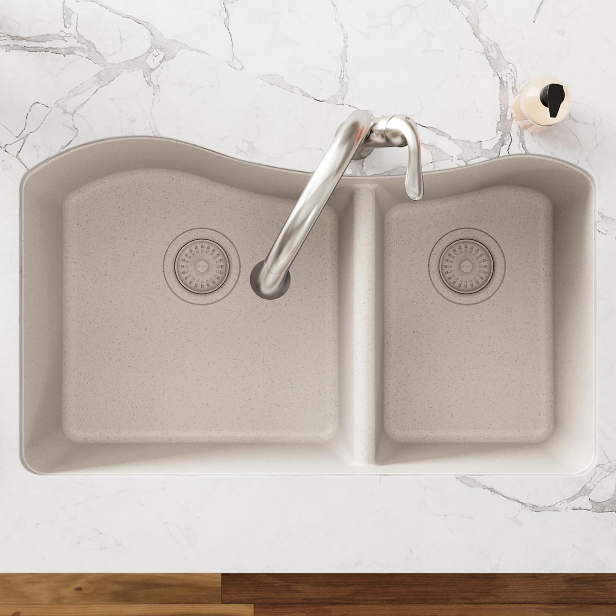 Parchment polymer double-bowl sink with brushed nickel faucet, drain basket strainers, and rubber stopper visible from above.