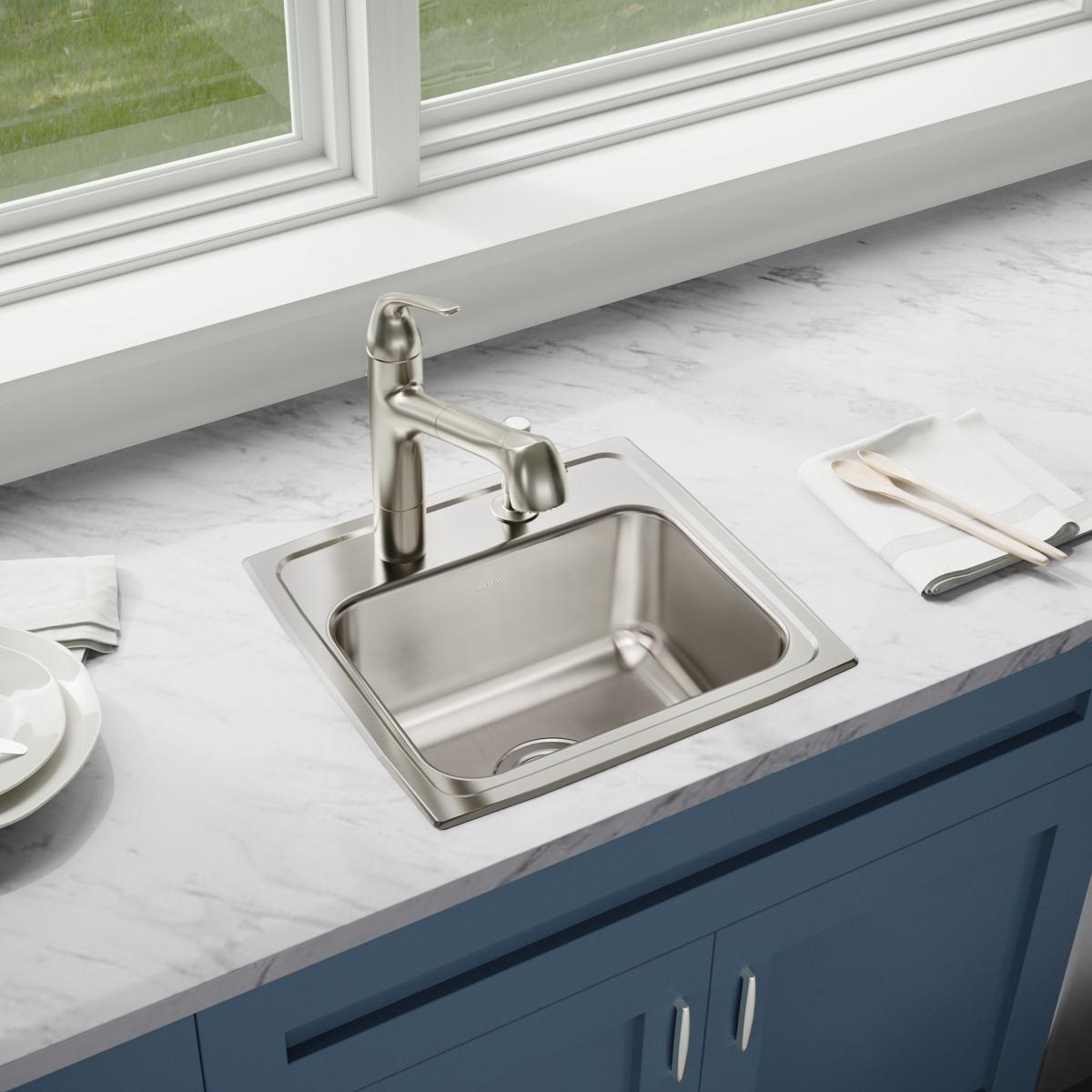 Stainless steel drop-in sink with single bowl and three pre-drilled holes, installed in white marble countertop with matching