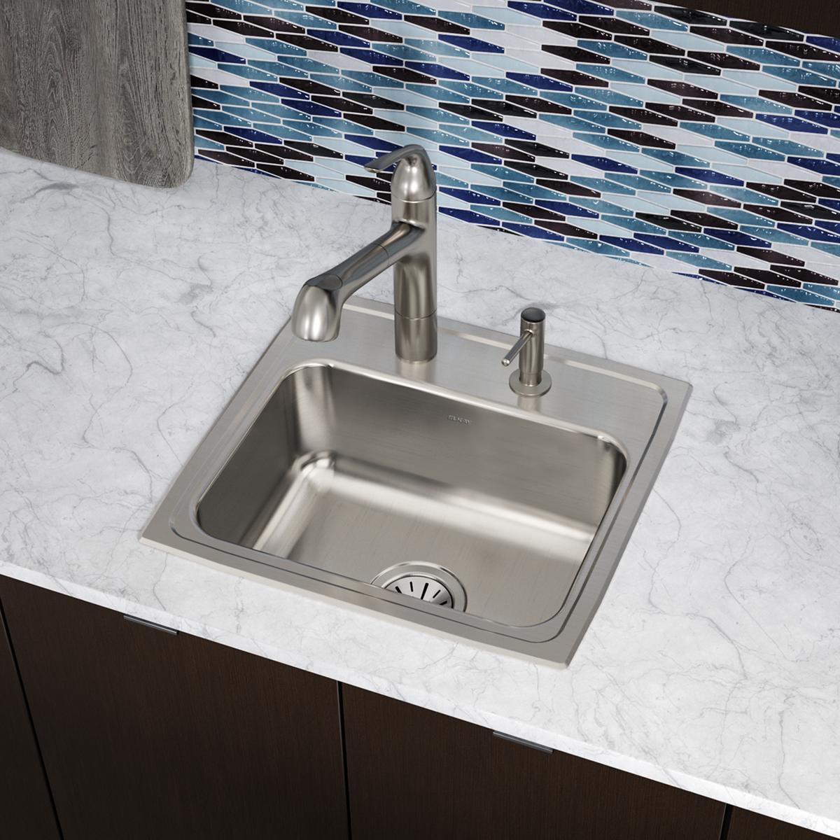 Stainless steel drop-in sink with single bowl, two faucet holes, and curved pull-down faucet on marble countertop.