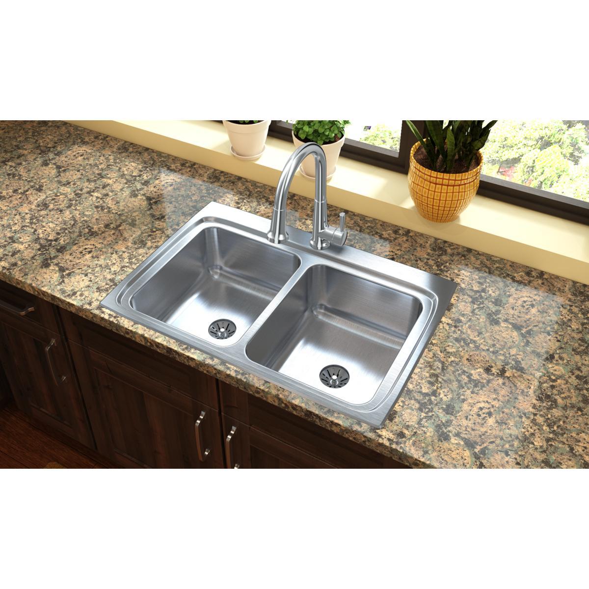 Stainless steel double bowl drop-in sink with two equal basins and drain holes installed in granite countertop with faucet.