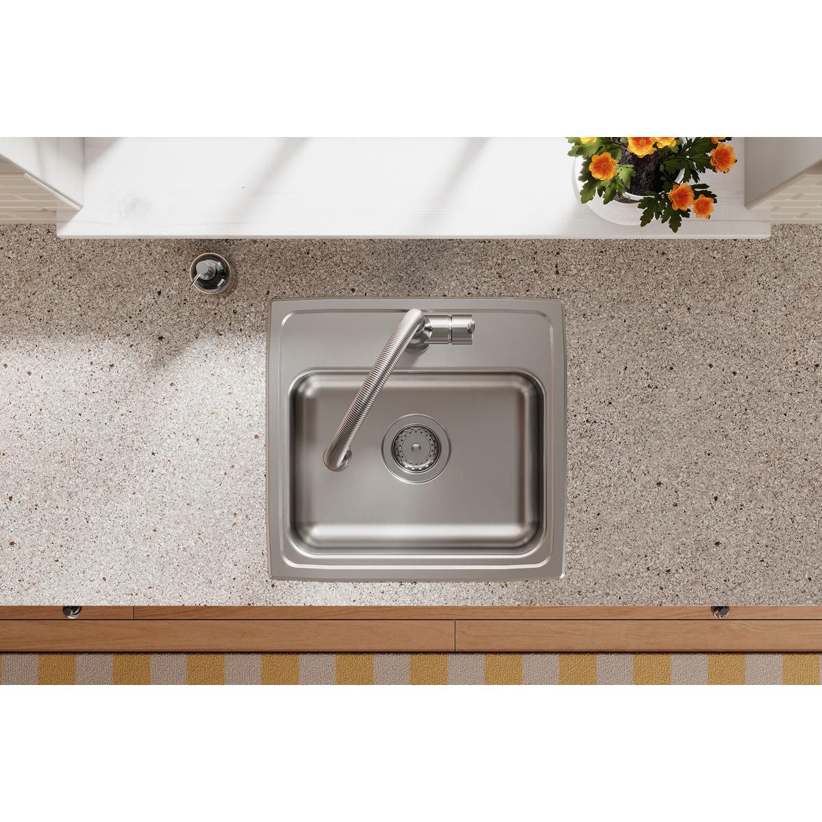 Stainless steel single bowl drop-in sink mounted in granite countertop with curved faucet and drain basket visible from above