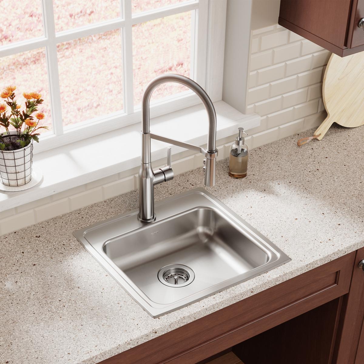 Stainless steel drop-in sink with single bowl and drain, installed in countertop with matching faucet.