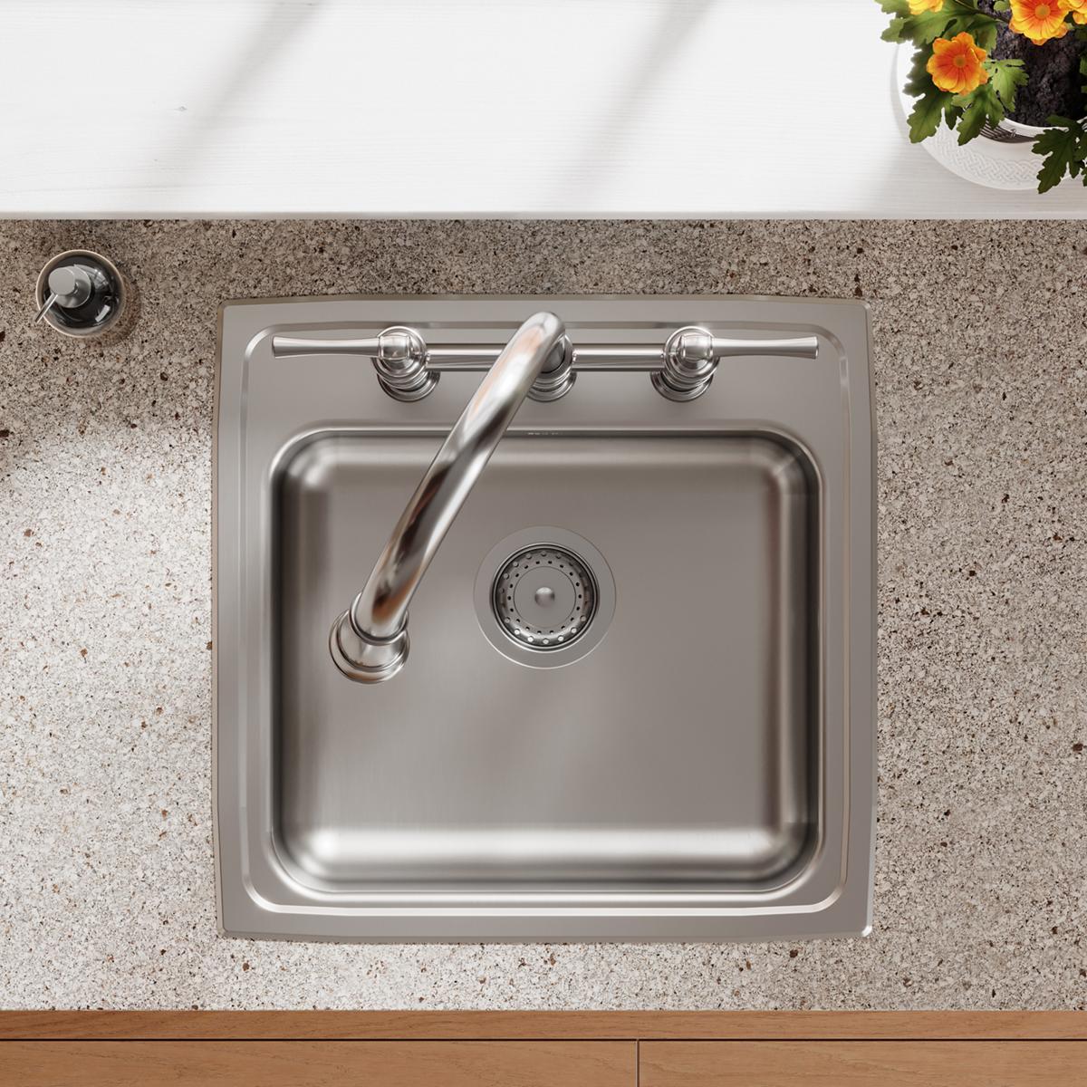 Stainless steel drop-in sink with single bowl, three faucet holes, drain strainer, and curved spout, installed in granite cou
