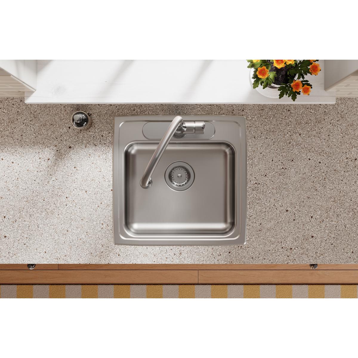 Stainless steel single bowl drop-in sink mounted in countertop with faucet and drain strainer visible from above.