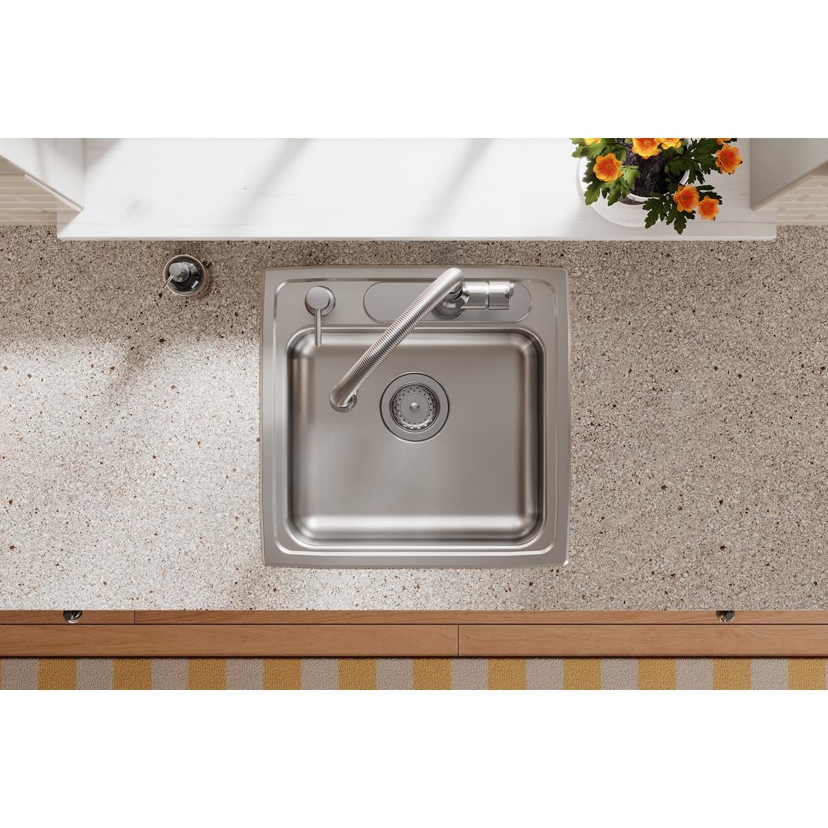 Stainless steel drop-in sink with single bowl, faucet, and drain strainer installed in countertop.