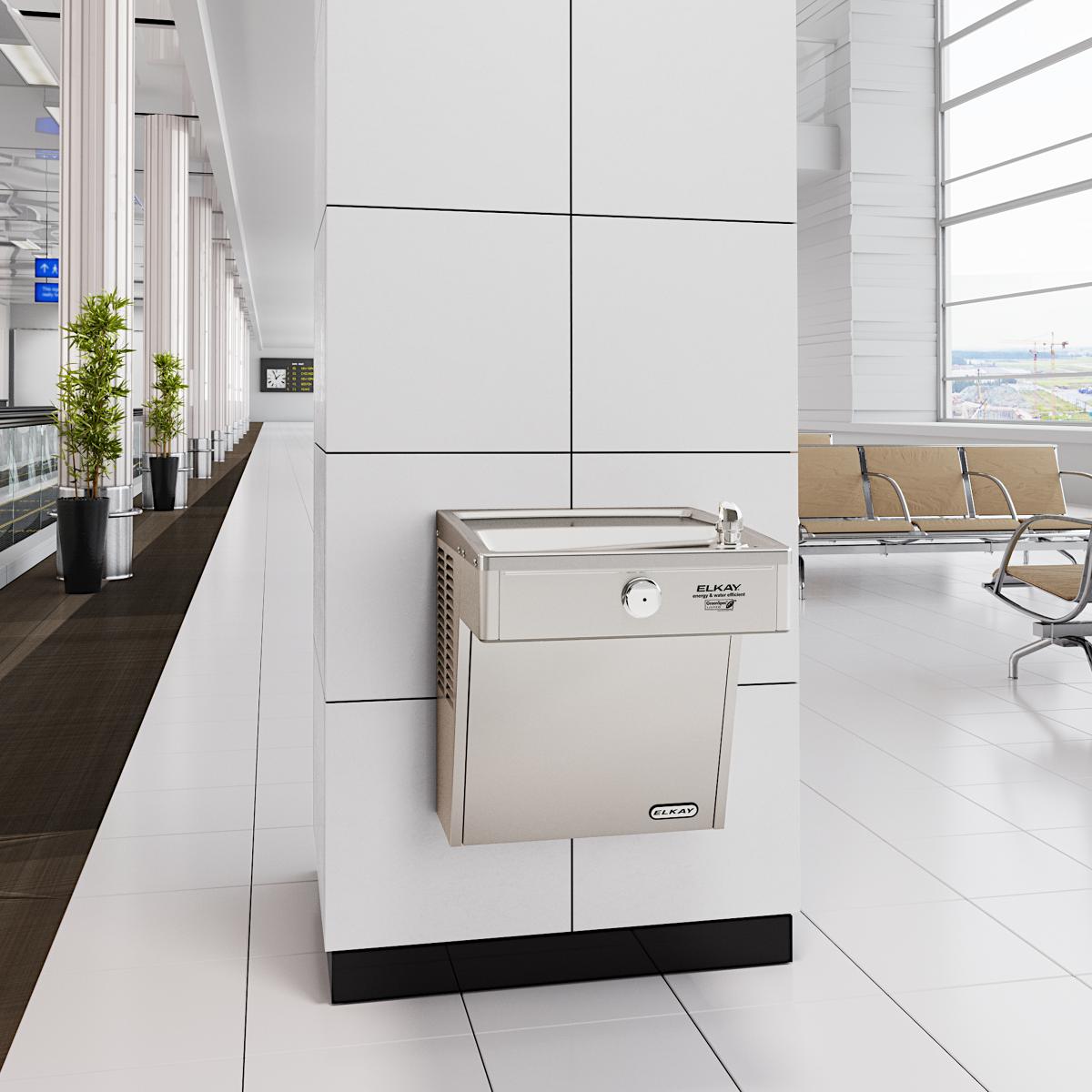 Stainless steel wall-mounted water cooler with filtered refrigerated dispenser in modern office hallway.