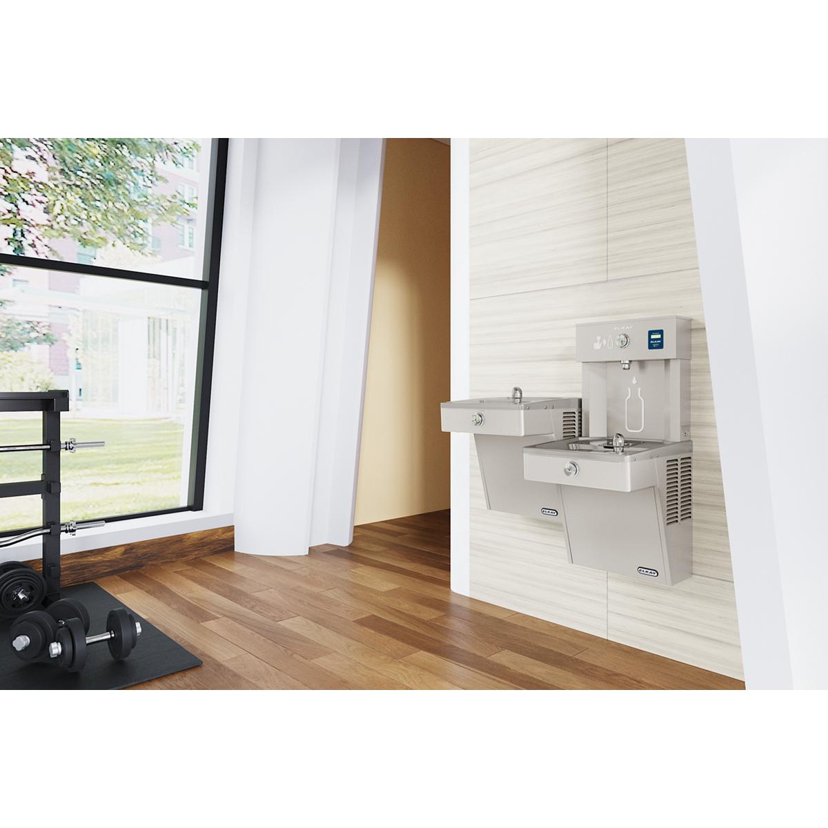 Stainless steel wall-mounted bi-level water filling station with bottle filler and cooler mounted in an indoor hallway.