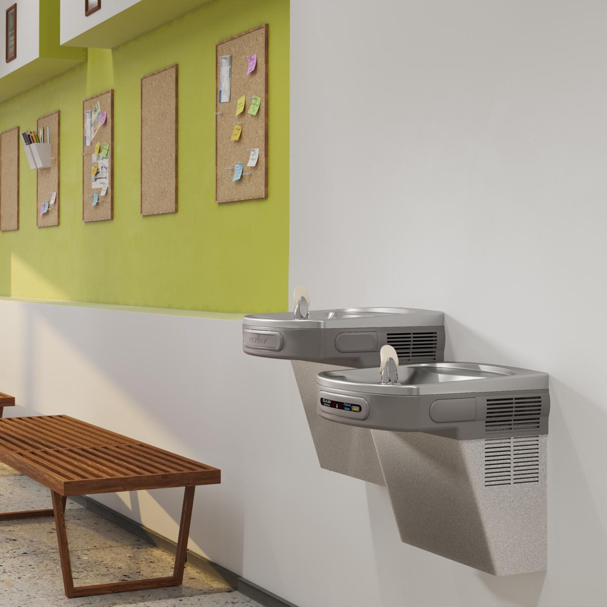 Wall-mounted light gray granite water cooler with two stainless steel drinking fountains at different heights for accessibili