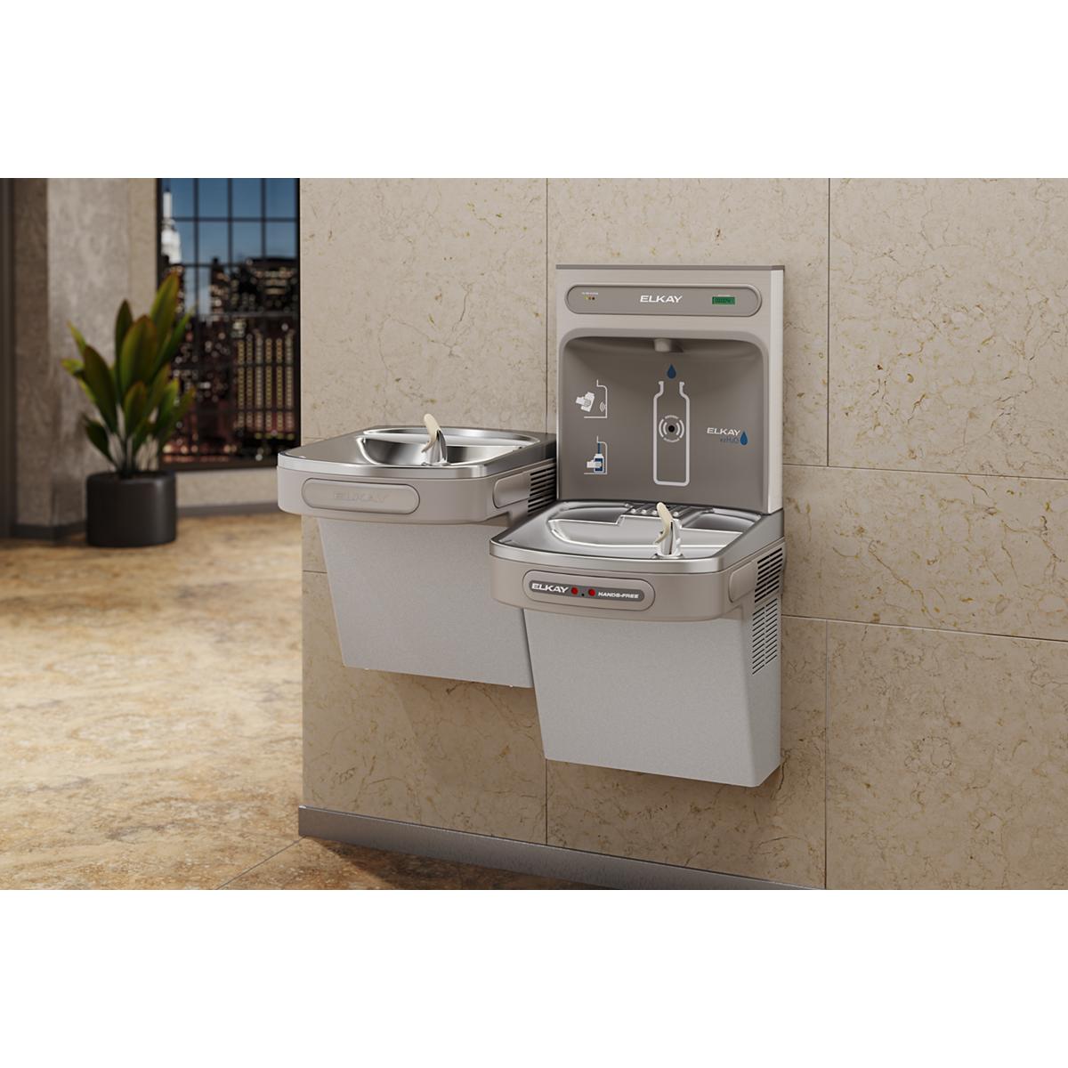 Light gray Elkay water fountain with dual filling stations mounted on wall, featuring bottle filling spouts and hands-free ac