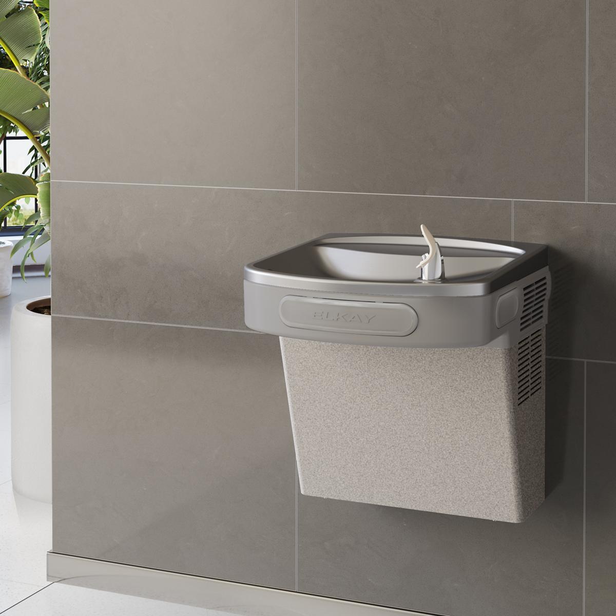 Wall-mounted water cooler in light gray granite with refrigerated basin and single drinking fountain spout.