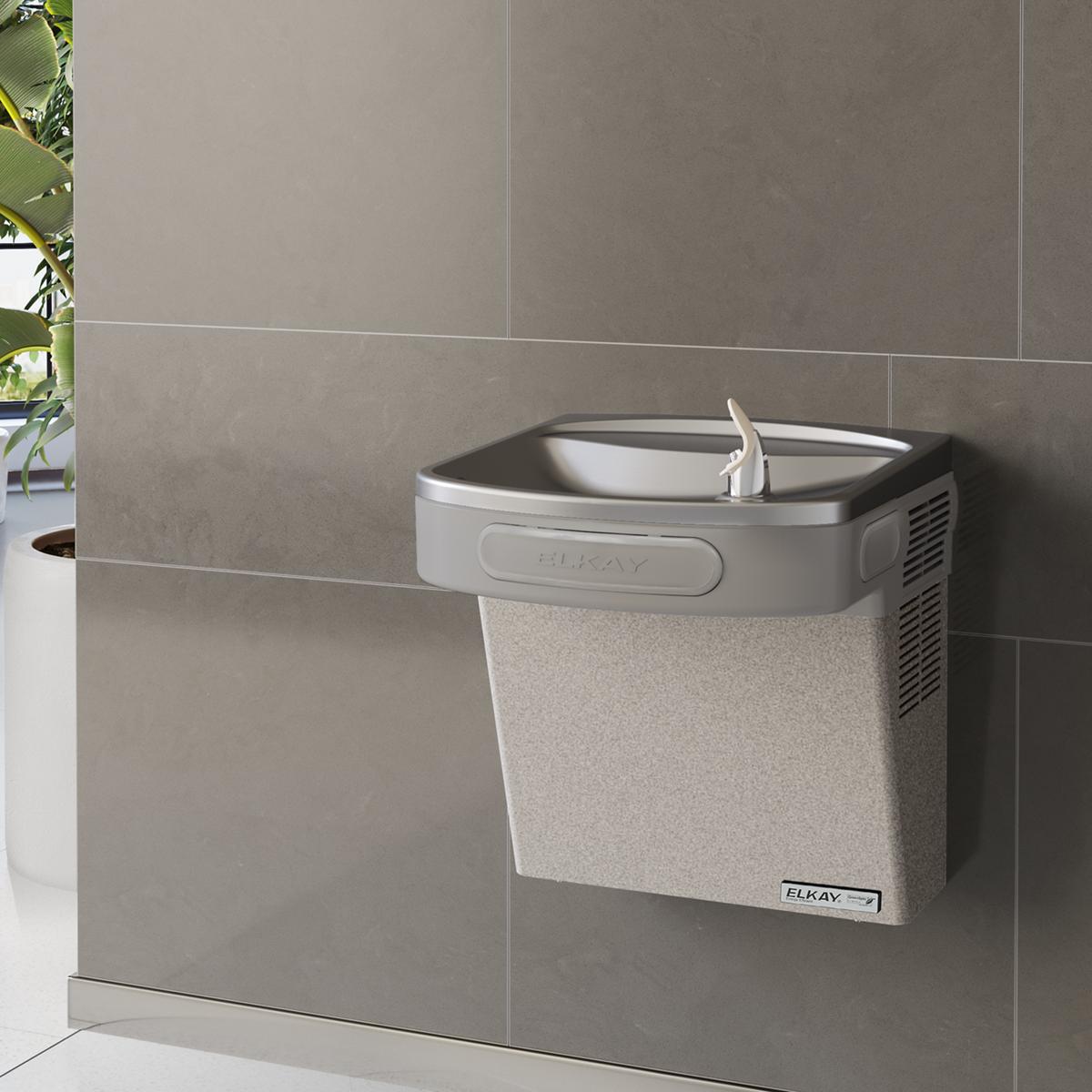 Light gray granite wall-mounted water cooler with curved basin and single faucet in tiled bathroom setting.