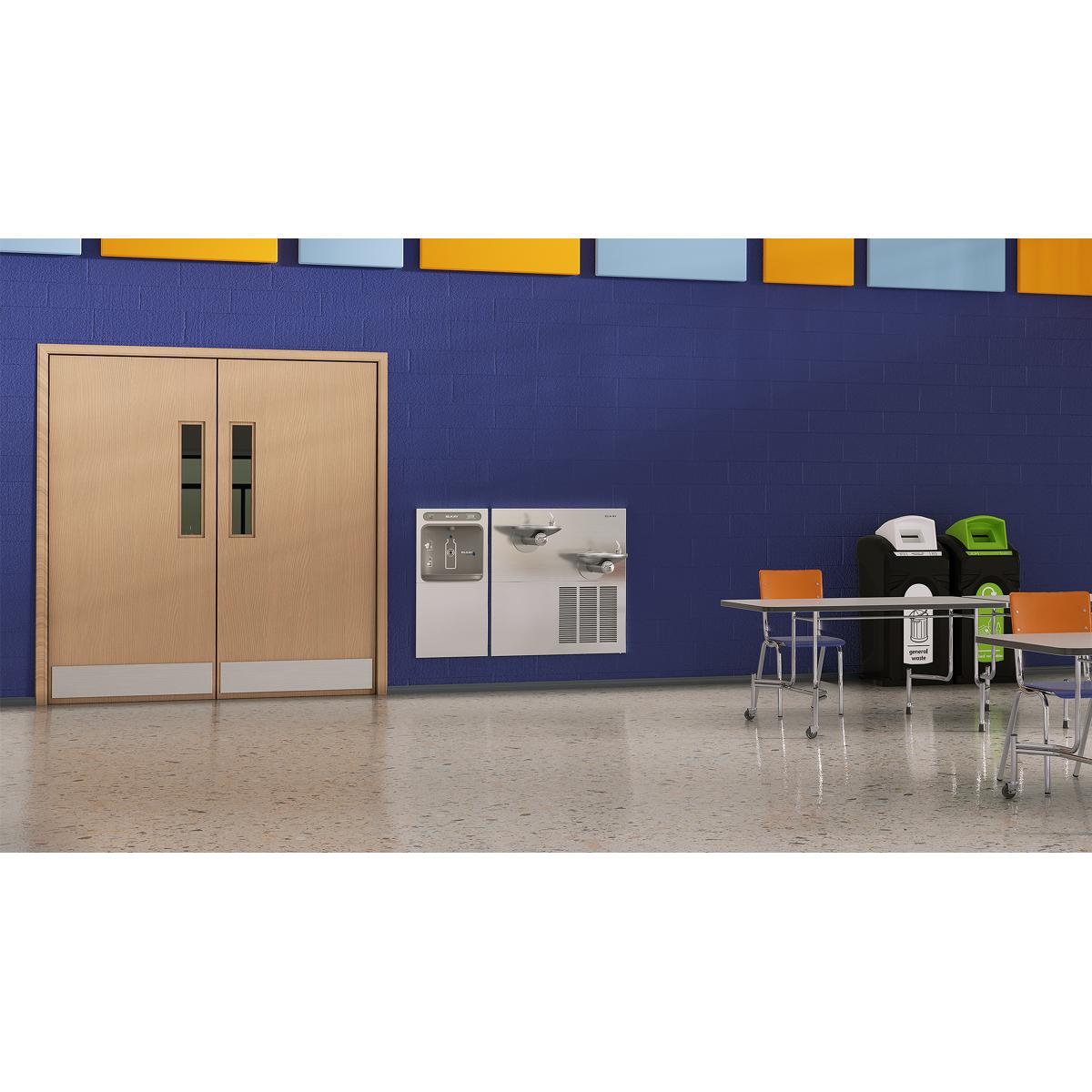 Stainless steel water fountain with bottle filling station and bi-level dispenser in institutional setting.