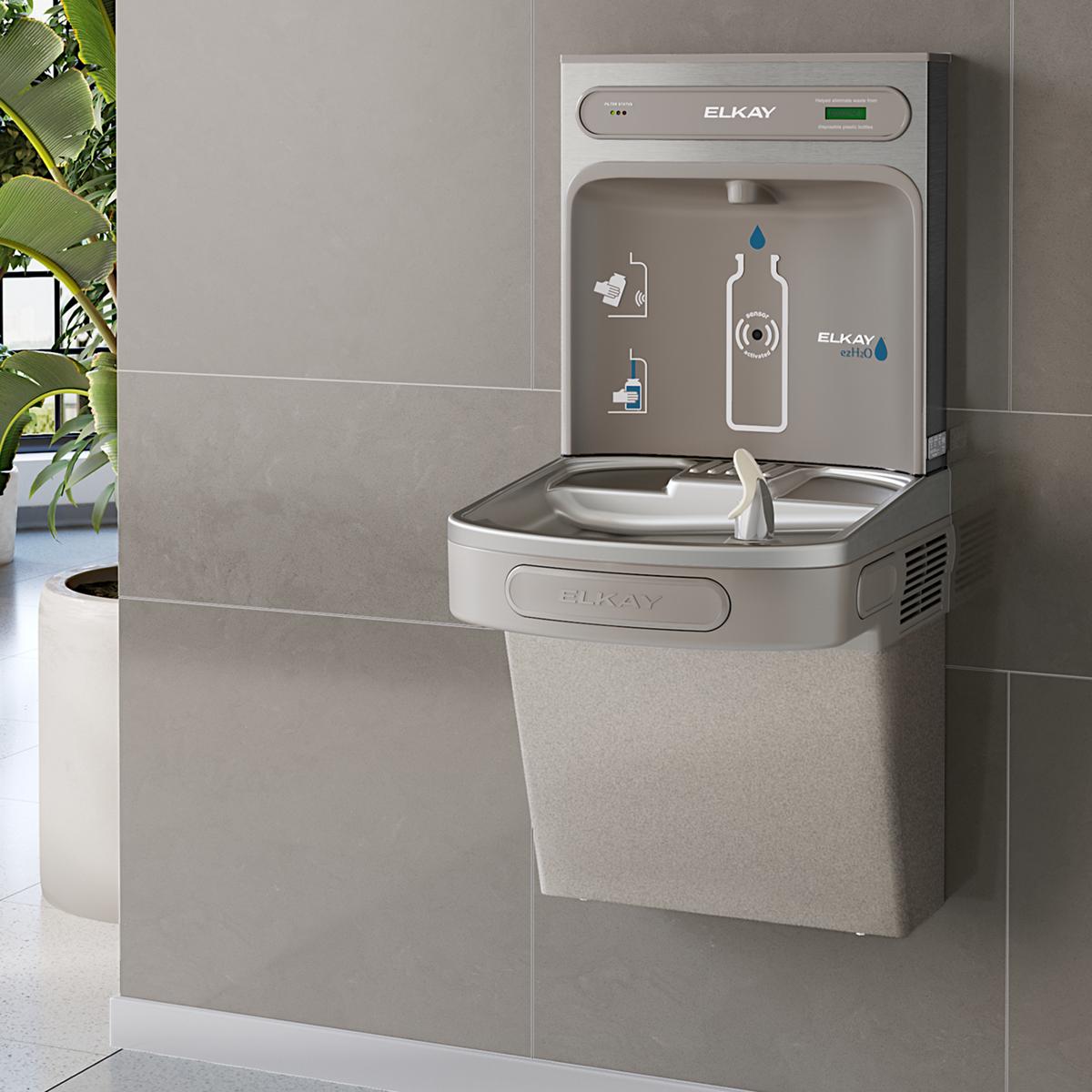 Elkay ezH2O non-refrigerated bottle filling station with gray and white exterior, mounted on wall with drip basin below.