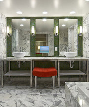 Three illuminated bathroom mirrors with integrated TV screens displaying a beach scene above marble countertops with vessel s
