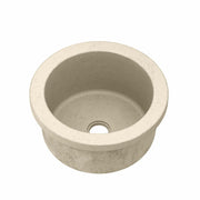 Sand-colored round concrete sink with single drainage hole, viewed from above.