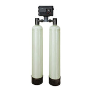 Dual fiberglass water treatment tanks with black control valve head and inlet/outlet ports mounted on top.