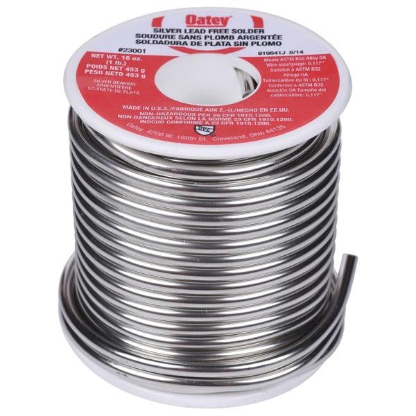 Oatey brand silver lead-free solder spool with red label and coiled metal wire.