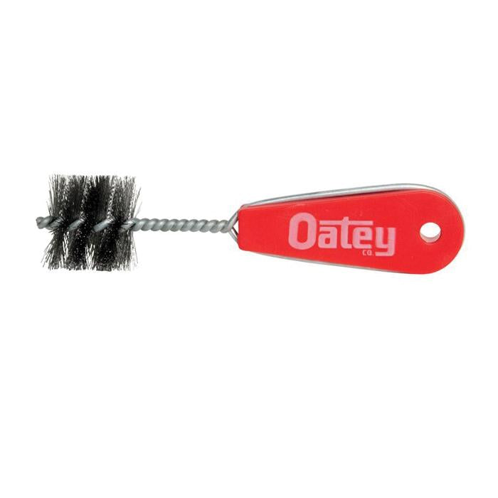 Cylindrical brush with black bristles, metal spiral shaft, and red plastic handle with Oatey branding.