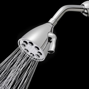 Polished chrome shower head with multiple spray holes and curved arm, dispensing water streams against black background.