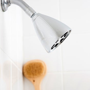 Polished chrome shower head with adjustable spray nozzle mounted on wall.