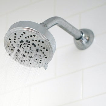 Polished chrome shower head with 7-inch curved arm and wall-mounted flange, water streams visible.