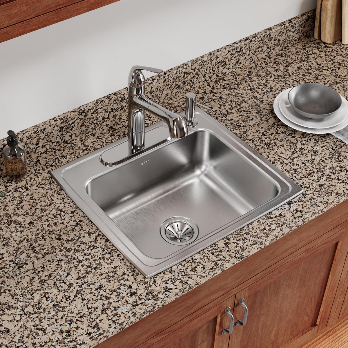 Stainless steel single bowl drop-in sink with four faucet holes installed in granite countertop with chrome faucet and drain 
