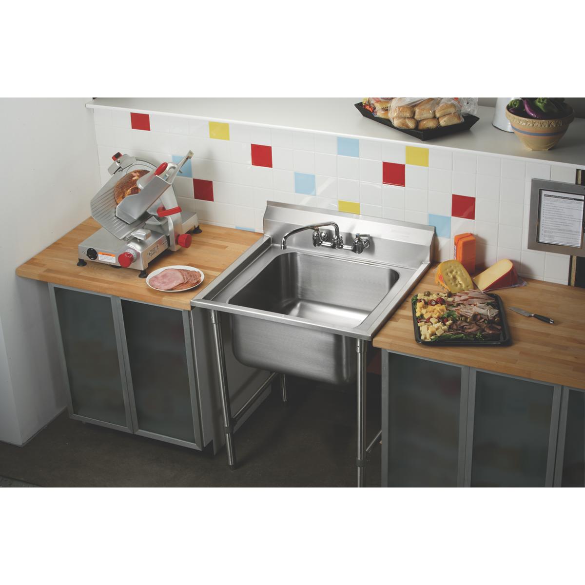 Stainless steel single-compartment scullery sink with faucet mounted on metal stand in commercial kitchen setting.