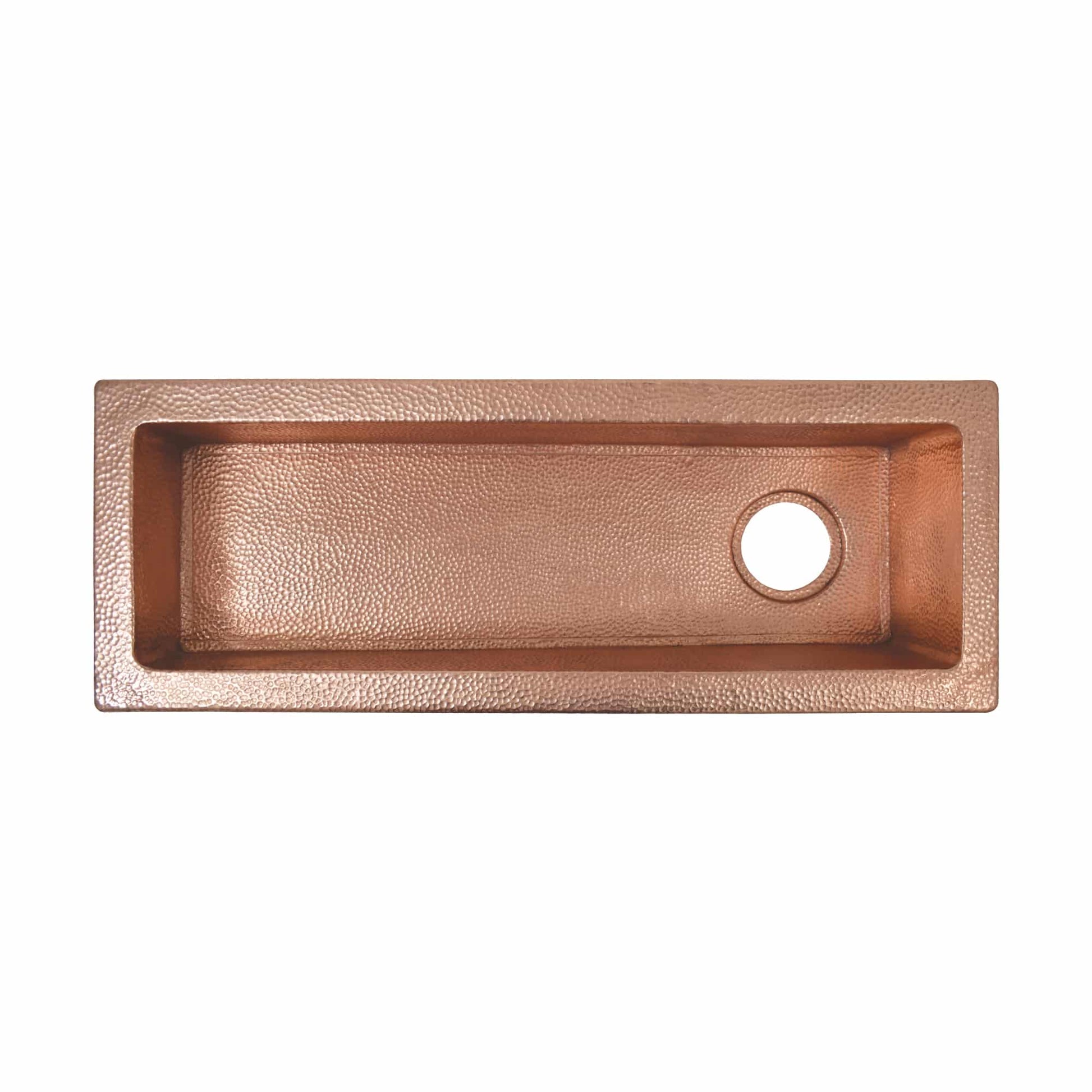 Polished copper rectangular sink with hammered texture and single drain hole, viewed from above.