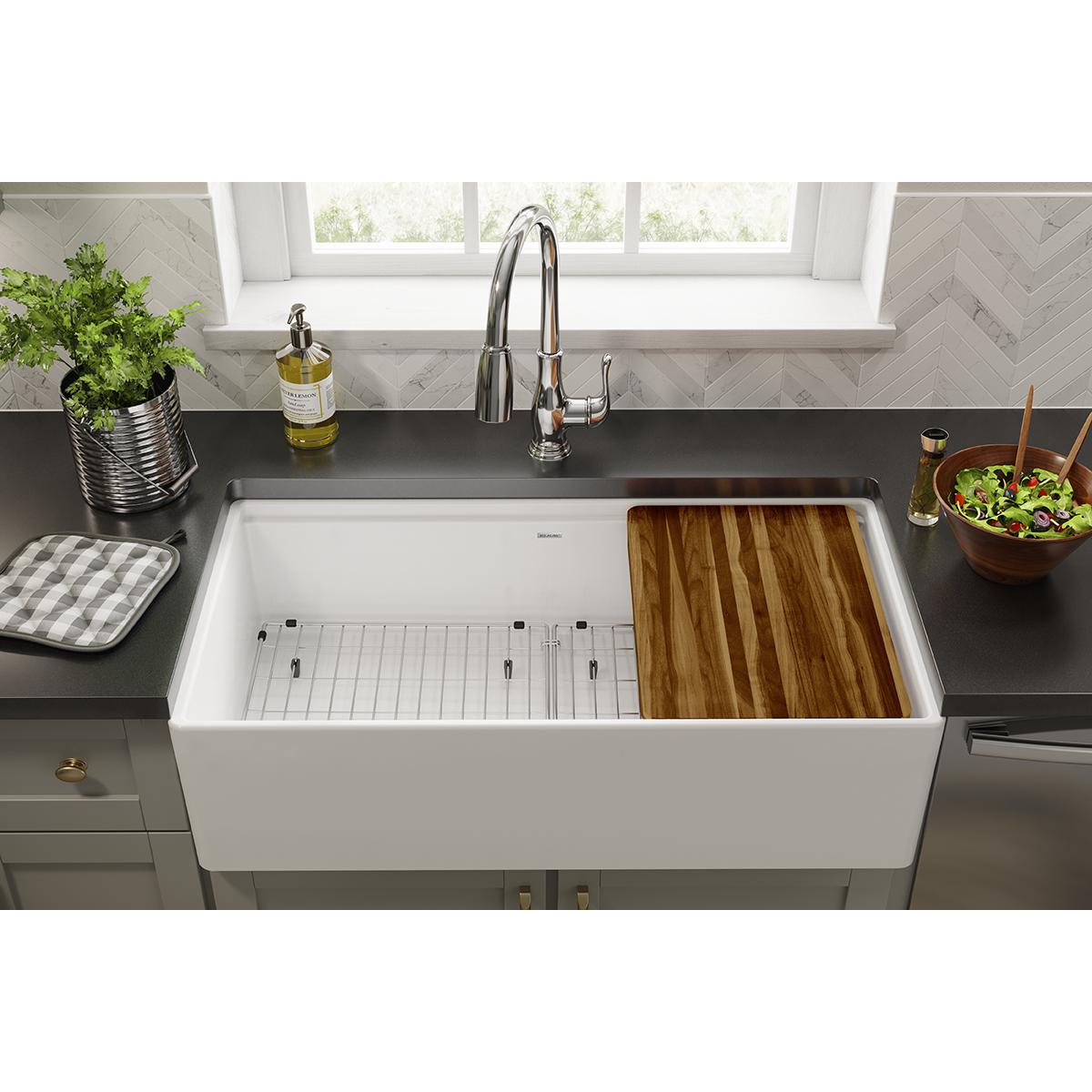 Stainless steel grid with linear slat pattern in white farmhouse sink basin.