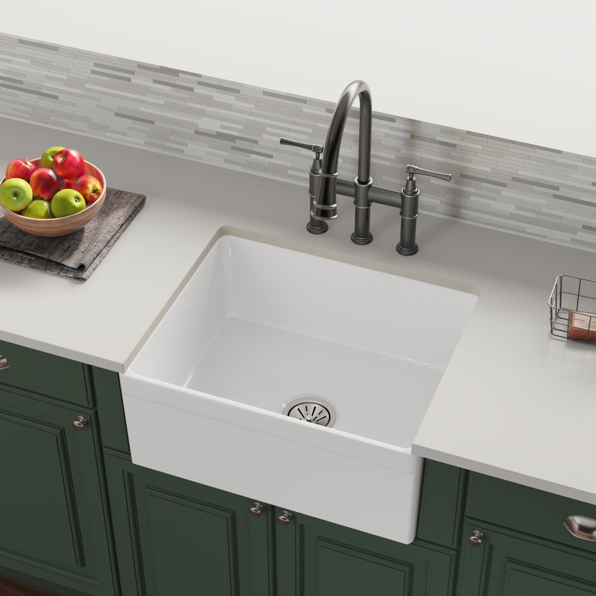 White fireclay farmhouse sink with single bowl, black faucet, and drain installed in countertop.