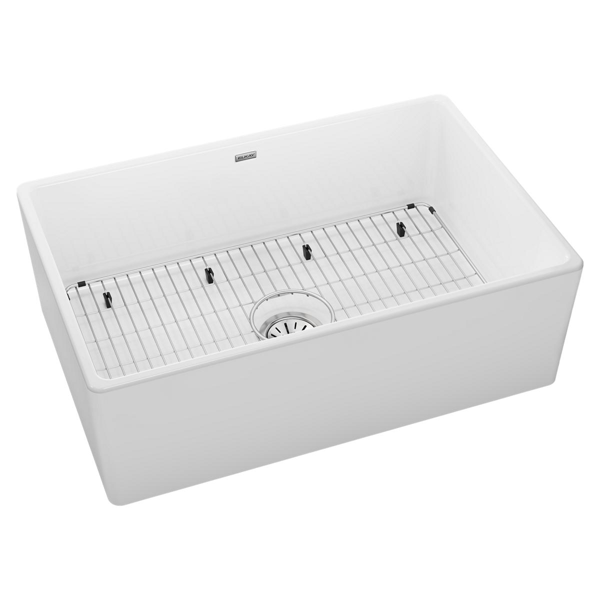 White fireclay farmhouse sink with single bowl, stainless steel grid and drain strainer.