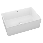 White fireclay single bowl farmhouse sink with apron front and drain opening.