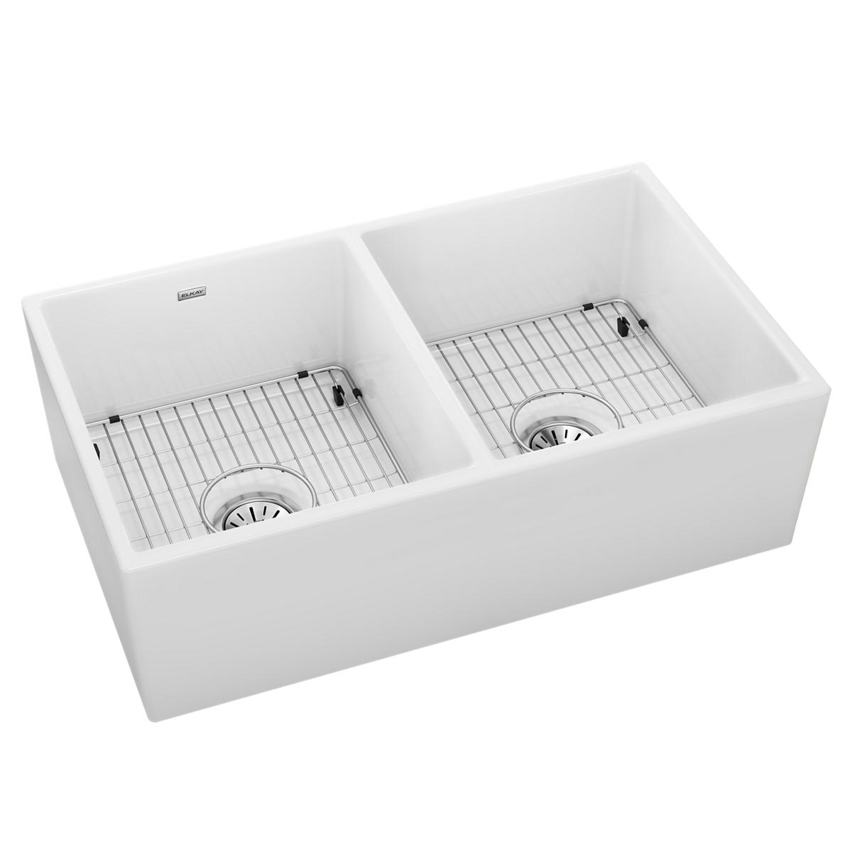 White fireclay farmhouse sink with two equal bowls, drain strainers, and metal basin grids.