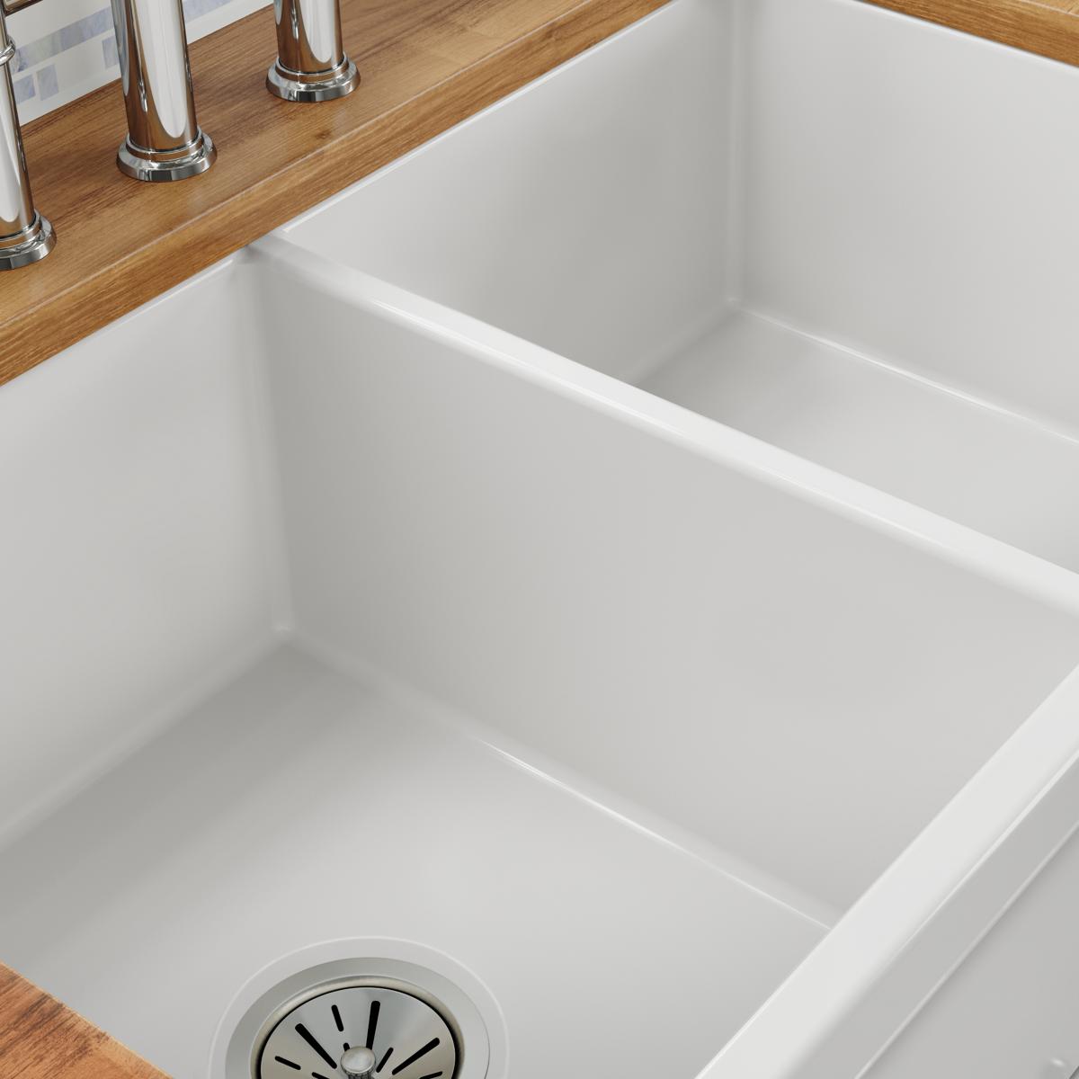 White fireclay farmhouse sink with two equal rectangular bowls and wooden countertop edge visible.