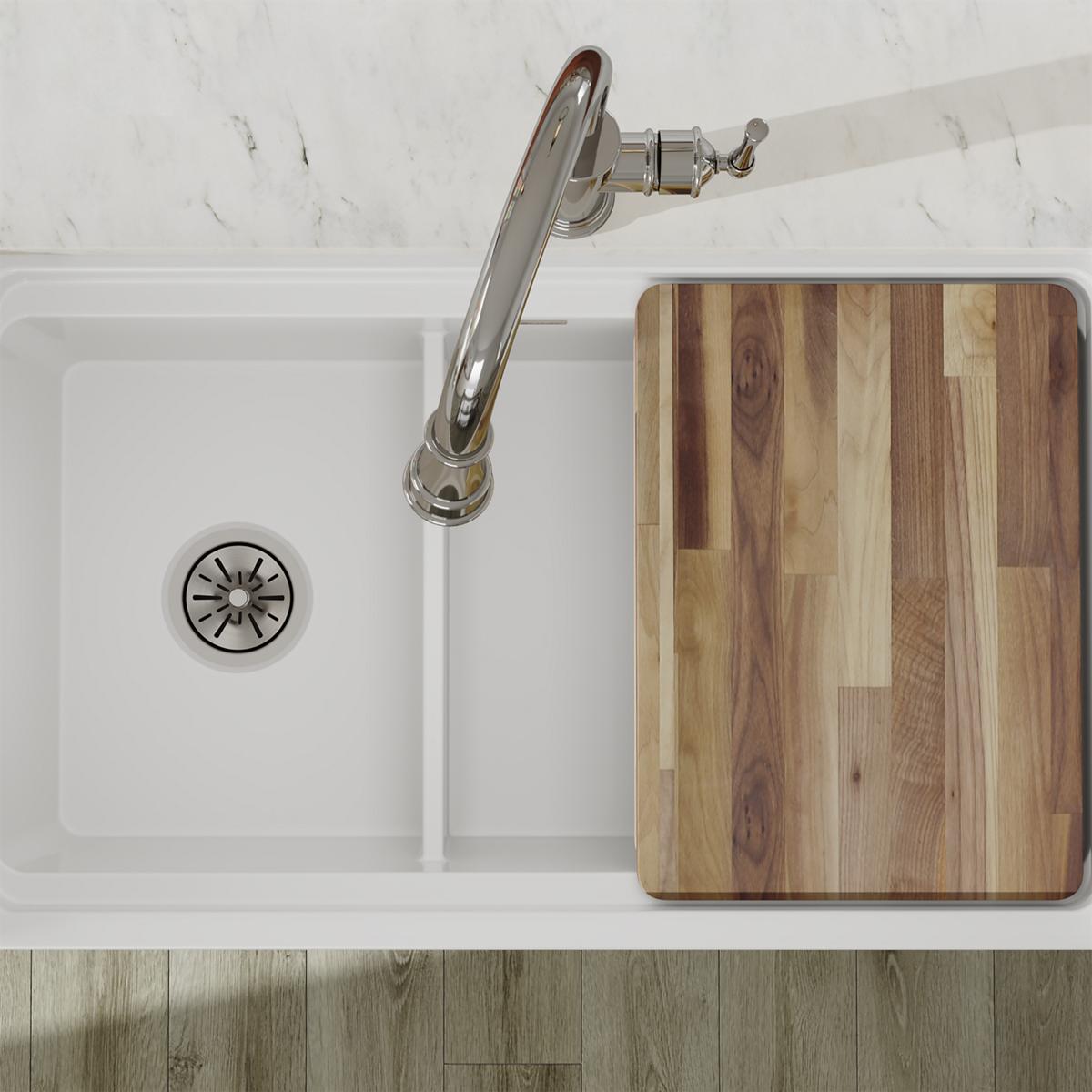White fireclay double bowl farmhouse sink with divide, chrome faucet, and wood cutting board, viewed from above.