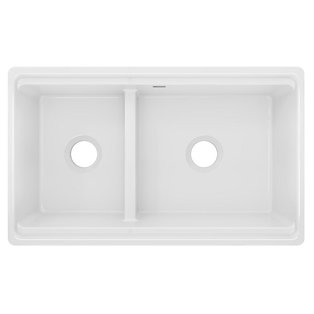 White fireclay double bowl farmhouse sink with two unequal bowls separated by divider and drain holes.