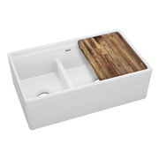 White fireclay double bowl farmhouse sink with unequal basins, divider, and wood cutting board accessory.