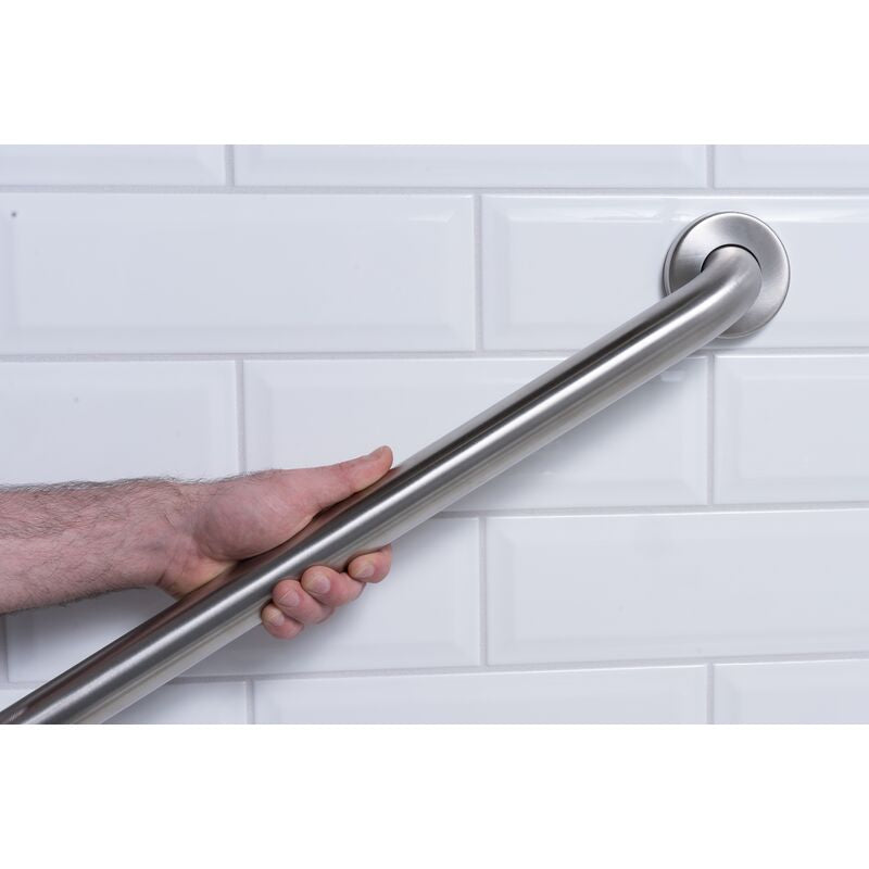 Stainless steel grab bar mounted horizontally on white subway tile wall with hand gripping it for demonstration.