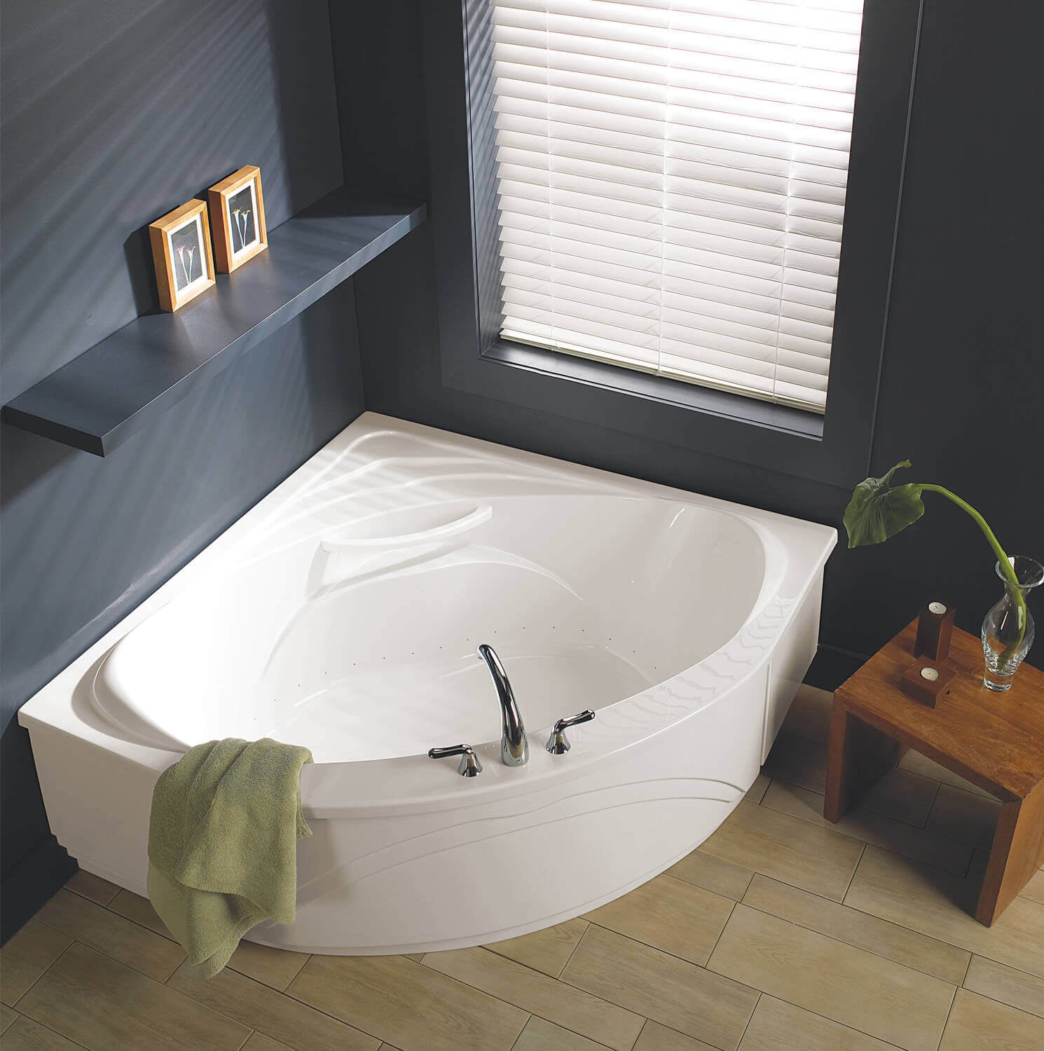 Biscuit-colored corner drop-in bathtub with curved interior, jet massage jets, and chrome fixtures installed in bathroom corn