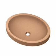 Terracotta-colored oval bathroom sink with centered drain hole and textured surface.