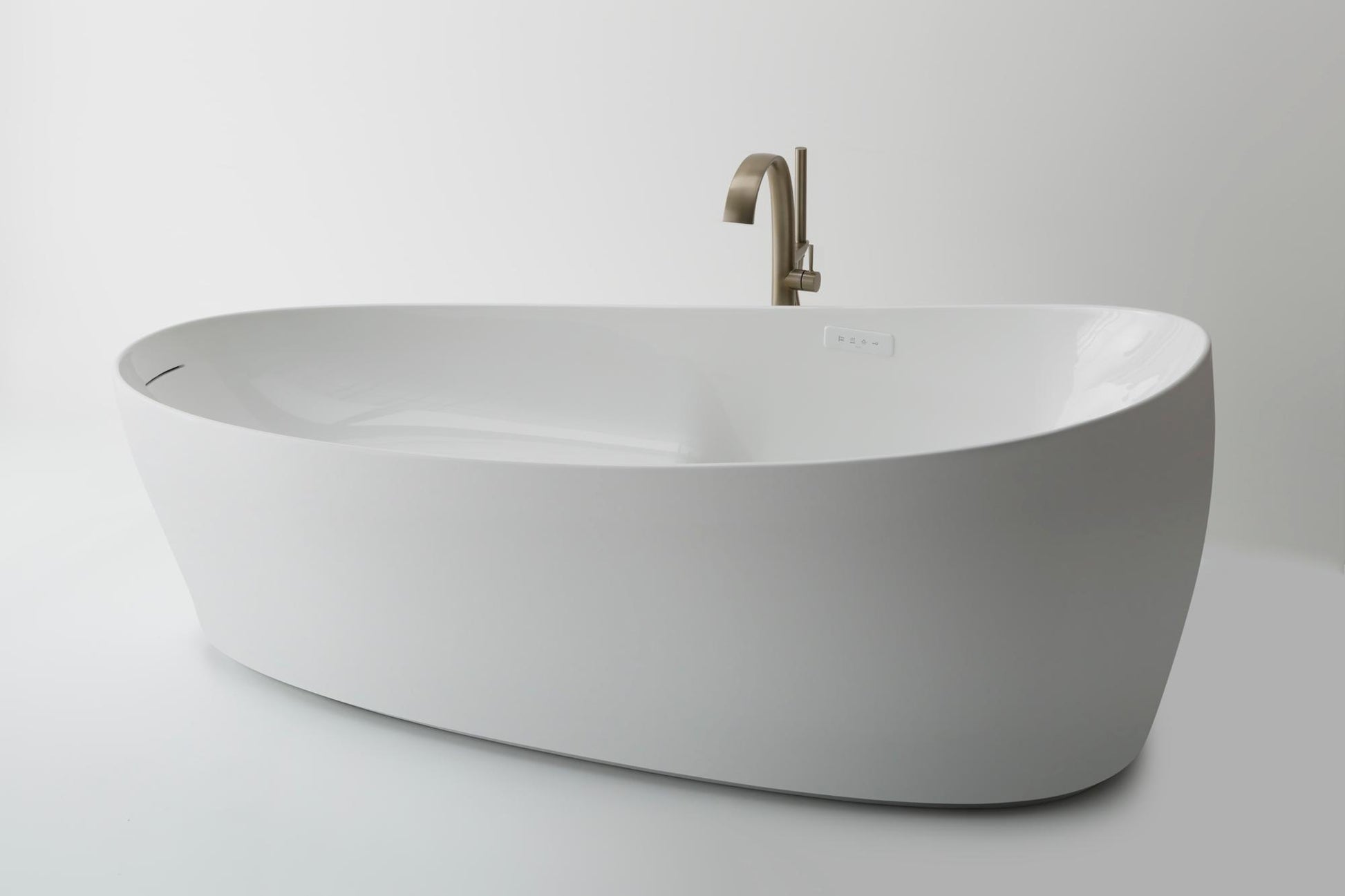 Gloss white freestanding oval bathtub with curved edges and brushed nickel faucet.
