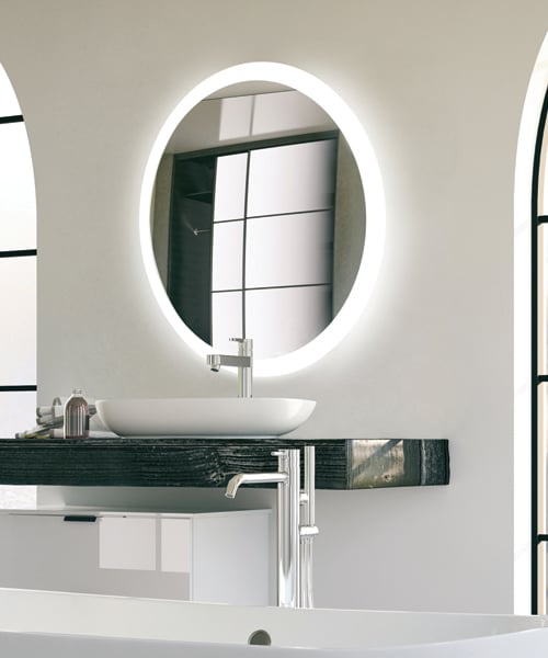 Oval lighted mirror with white LED border mounted above black vanity sink in bathroom.